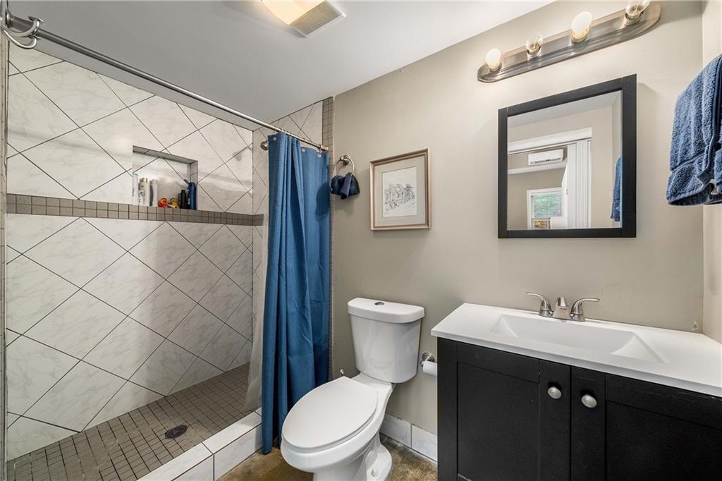 911 Monroe Circle Northeast Atlanta, GA 30308 - Photo 47 of 86 a bathroom with a toilet a sink and mirror