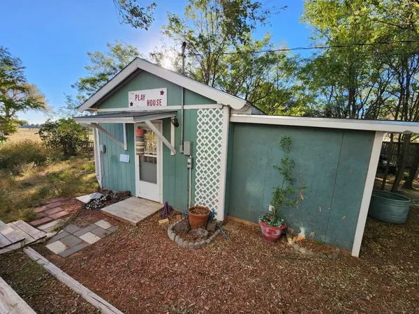 a view of a chair and table in backyard of the house