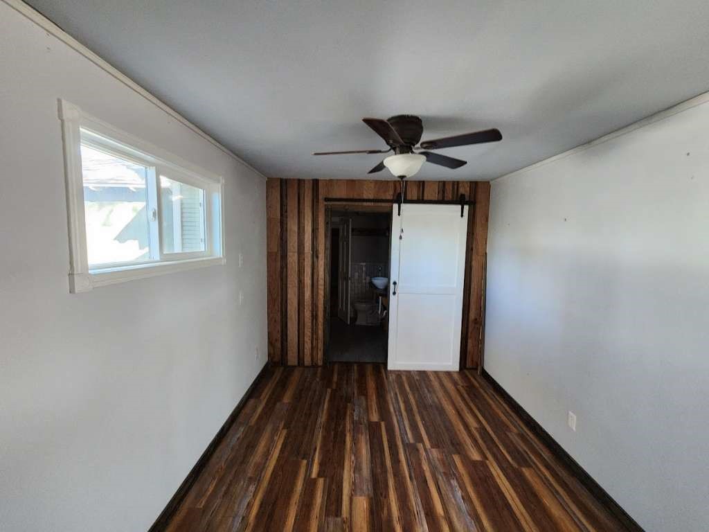 108 East 9th Street Channing, TX 79018 - Photo 10 of 16 a view of a hallway with wooden floor and a ceiling fan