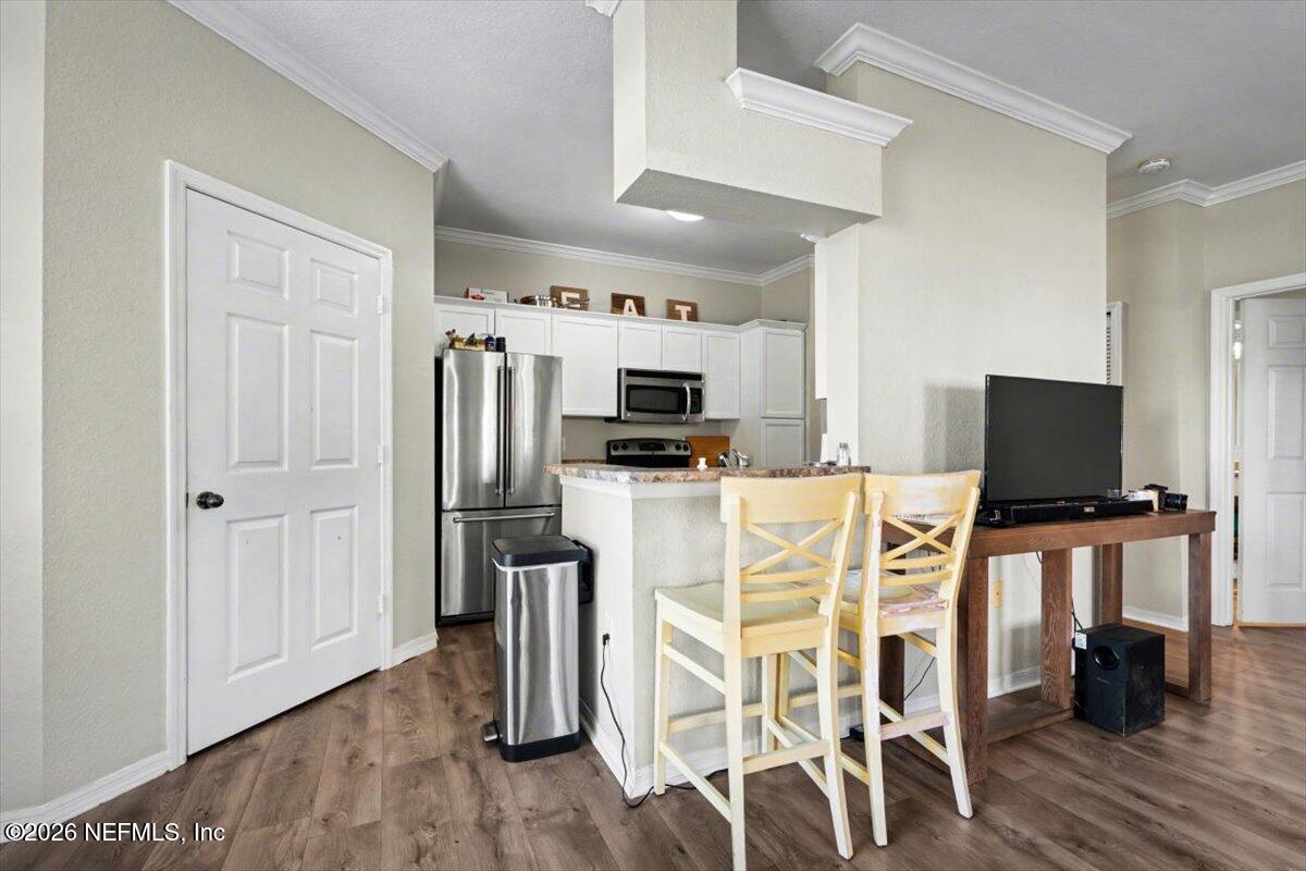 10961 Burnt Mill Road, Unit 1017 Jacksonville, FL 32256 - Photo 11 of 26 a kitchen with stainless steel appliances kitchen island granite countertop a refrigerator and microwave