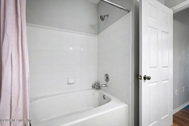 a white bath tub sitting next to a shower