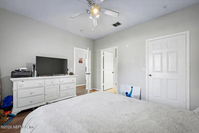 a bedroom with a large bed and a flat tv screen on dresser