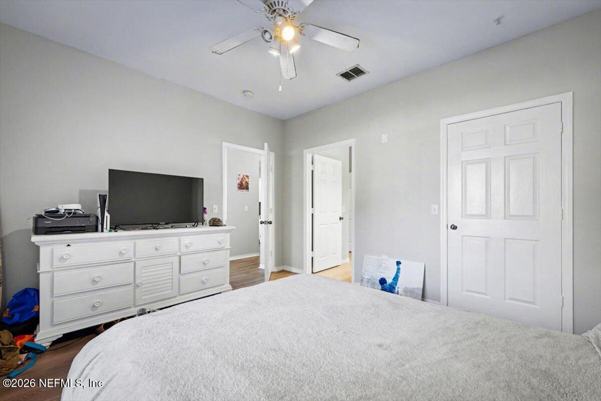 10961 Burnt Mill Road, Unit 1017 Jacksonville, FL 32256 - Photo 17 of 26 a bedroom with a large bed and a flat tv screen on dresser