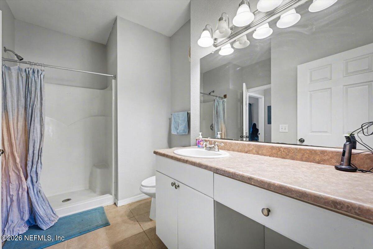 10961 Burnt Mill Road, Unit 1017 Jacksonville, FL 32256 - Photo 18 of 26 a bathroom with a granite countertop sink a toilet and shower