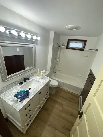 a bathroom with a sink a large mirror and a toilet