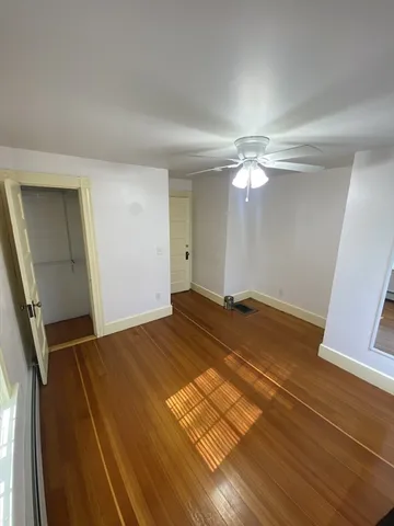 a view of a livingroom with wooden floor and staircase