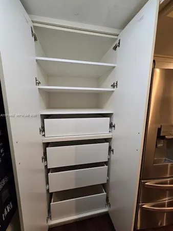 a view of walk in closet with empty racks