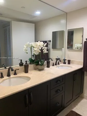 a bathroom with double vanity and a mirror