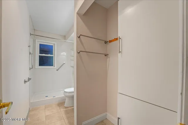 a bathroom with white cabinets and toilet