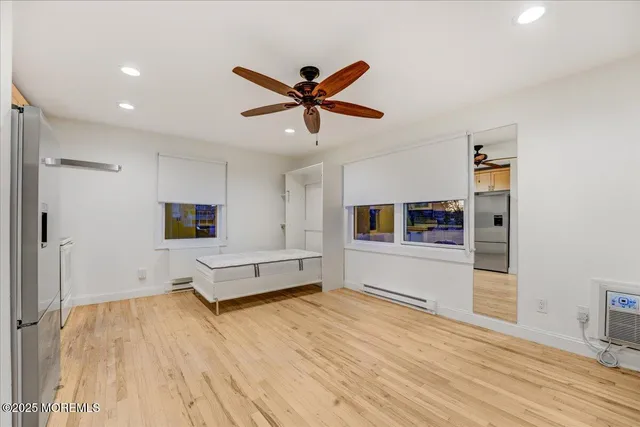 a view of empty room with wooden floor and ceiling fan