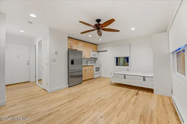 a kitchen with a refrigerator stove and white cabinets