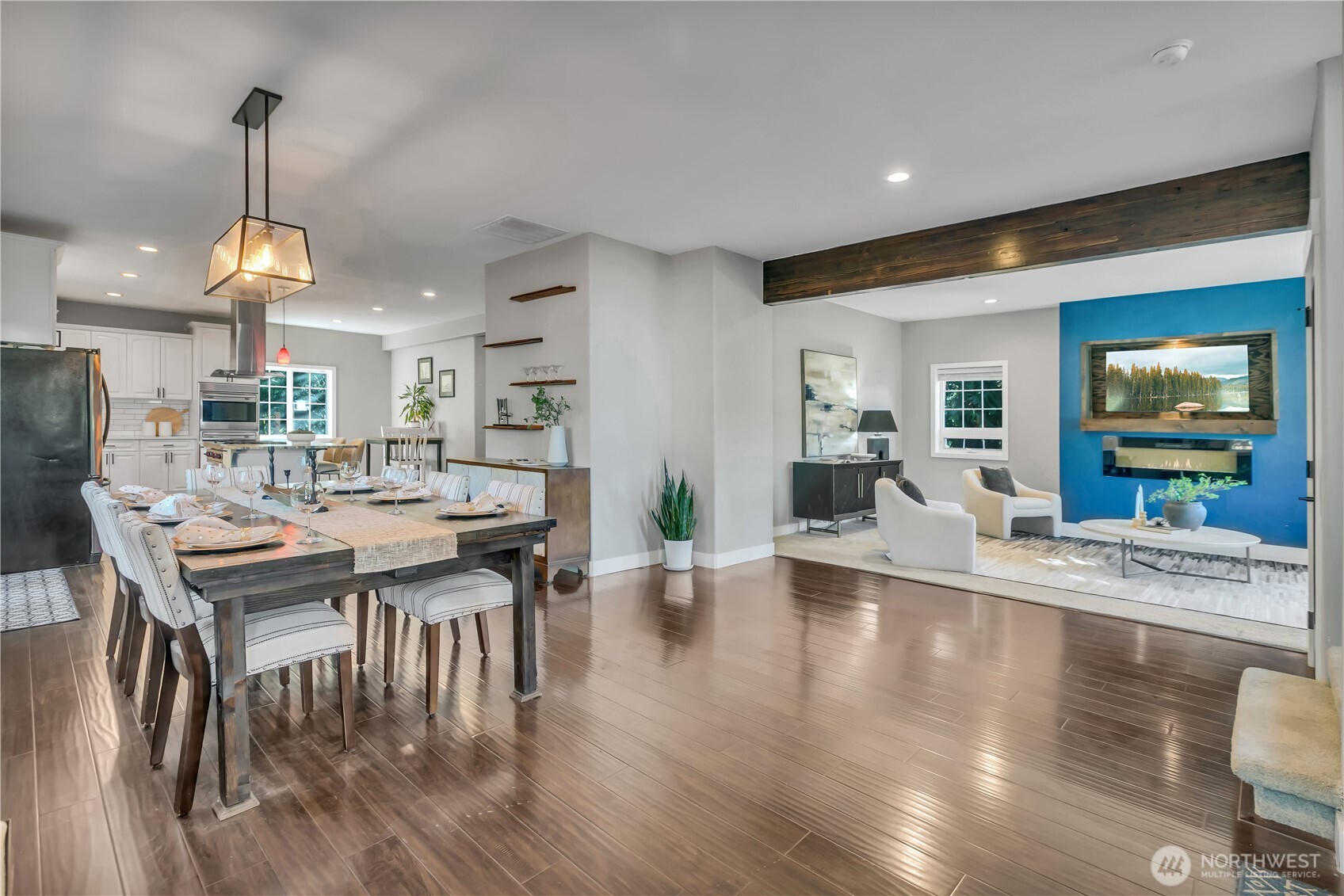 a view of a dining room and livingroom with furniture wooden floor a chandelier