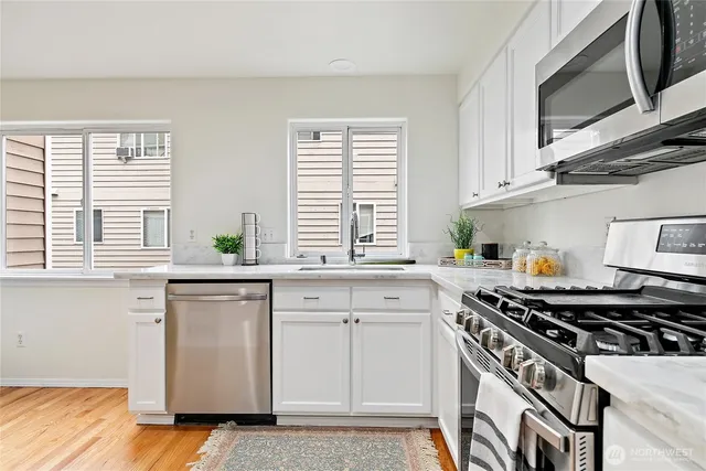 a kitchen with stainless steel appliances a sink stove and cabinets