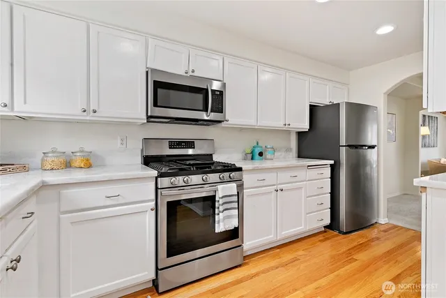 a kitchen with white cabinets and stainless steel appliances