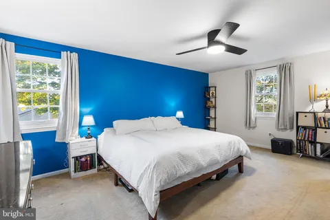 a bedroom with a bed a mirror and a large window