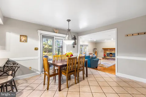a dining room with furniture a chandelier and fireplace
