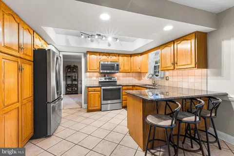 a kitchen with stainless steel appliances granite countertop a sink a stove and a refrigerator