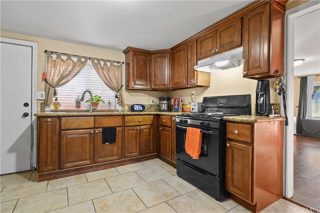 7434 Evans Street Riverside, CA 92504 - Photo 6 of 16 a kitchen with stainless steel appliances granite countertop a refrigerator a sink dishwasher a stove and a microwave oven with granite countertops