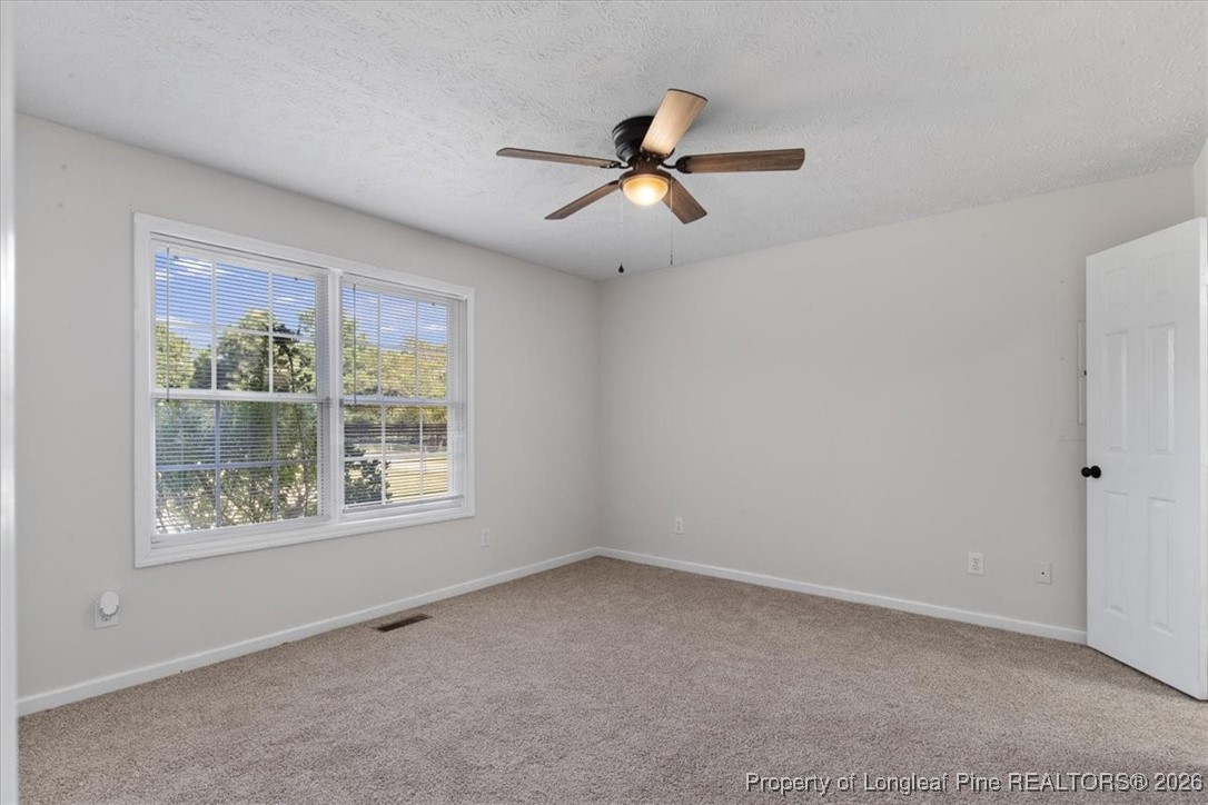 151 Ballard Drive Raeford, NC 28376 - Photo 12 of 34 an empty room with a window and a fan