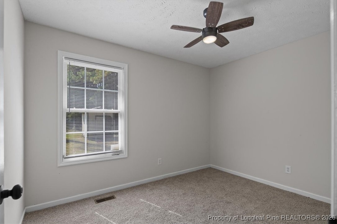 151 Ballard Drive Raeford, NC 28376 - Photo 26 of 34 an empty room with a window and a ceiling fan