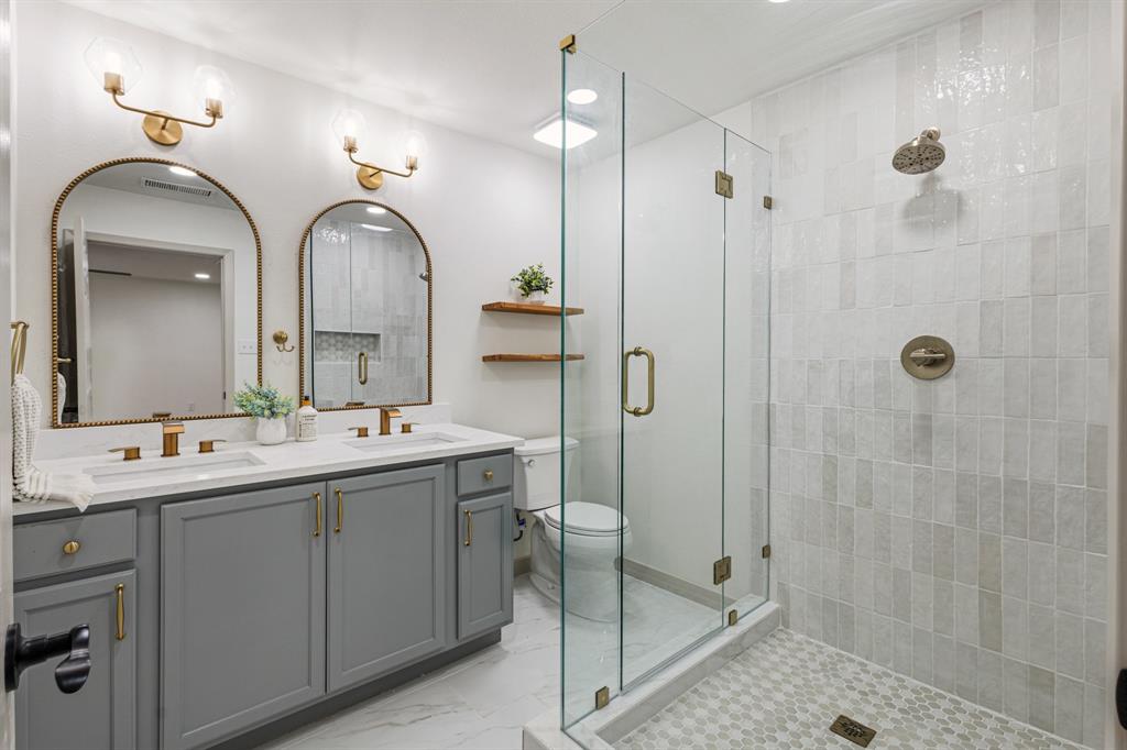 1510 Finley Road Irving, TX 75062 - Photo 12 of 17 a bathroom with a double vanity sink mirror and shower