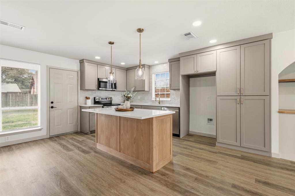 1510 Finley Road Irving, TX 75062 - Photo 6 of 17 a kitchen with stainless steel appliances granite countertop a refrigerator a sink dishwasher a stove and white countertops with wooden floor