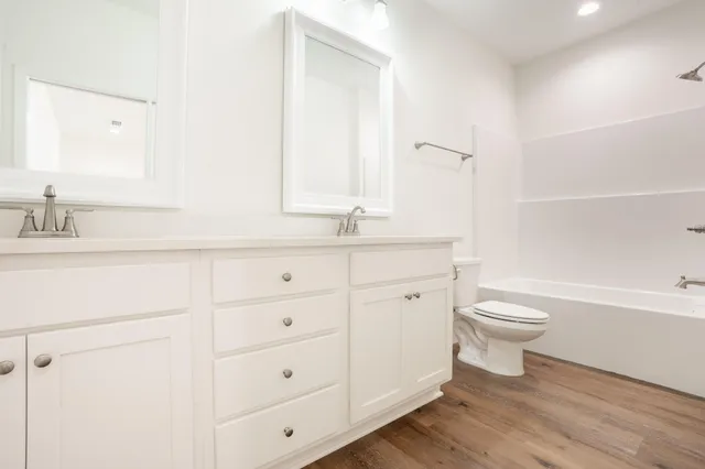a bathroom with a granite countertop toilet sink and a mirror