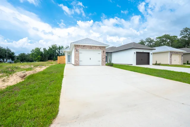 a view of a house with a big yard and potted plants