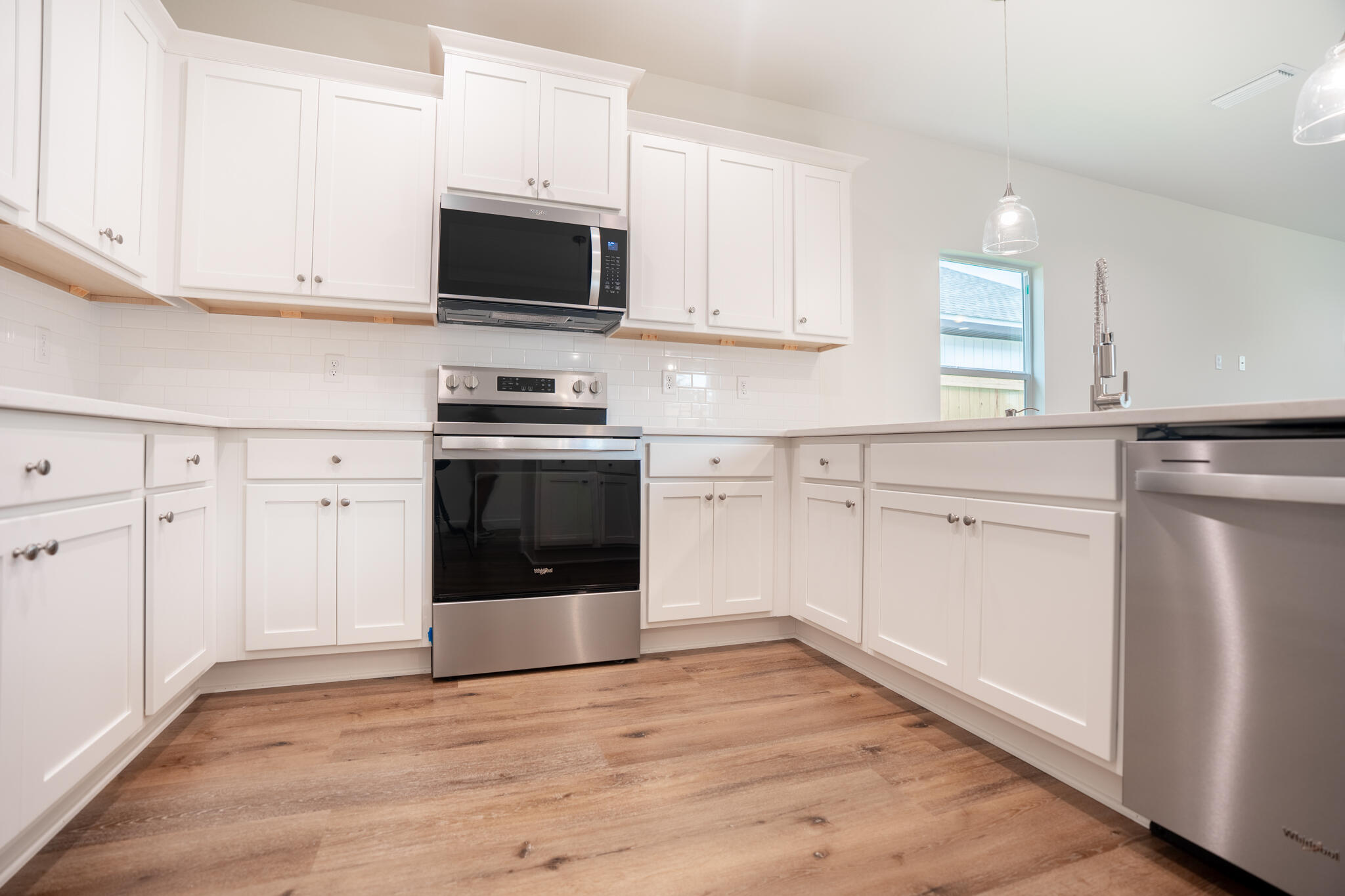 21 B 5th Avenue Shalimar, FL 32579 - Photo 7 of 21 a kitchen with white cabinets stainless steel appliances and sink