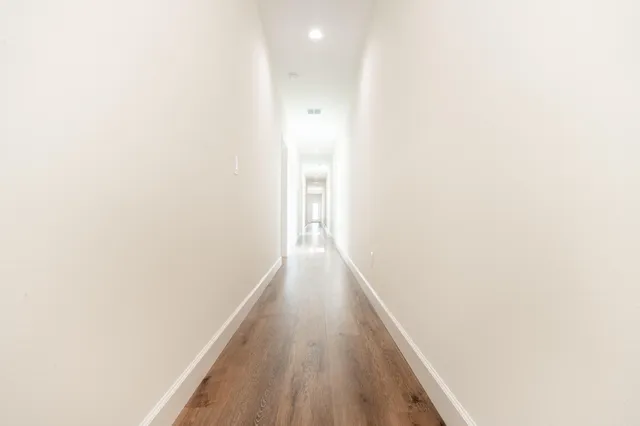 a view of a hallway with wooden floor