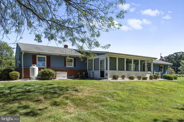 a front view of a house with a yard and trees