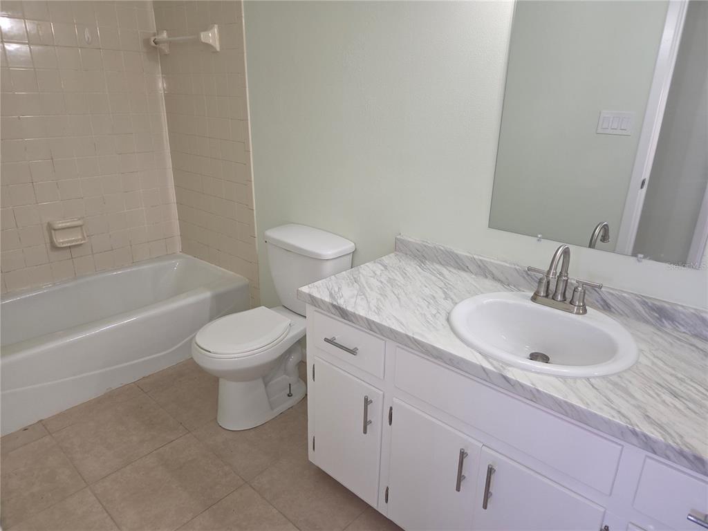 17026 Highway 54 Lutz, FL 33558 - Photo 8 of 13 a bathroom with a granite countertop sink toilet and shower