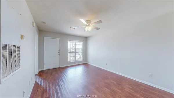 wooden floor in an empty room with a window
