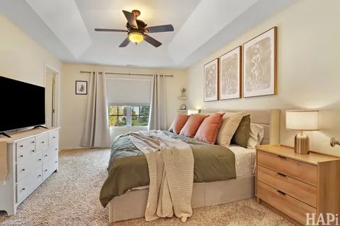 a spacious bedroom with a bed and a flat screen tv