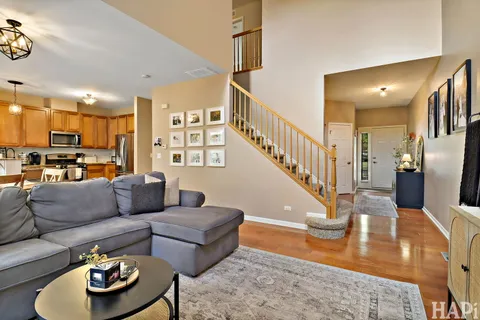 a living room with furniture and a dining table with wooden floor