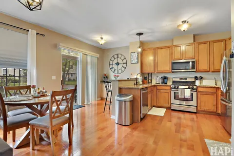 a kitchen with stainless steel appliances kitchen island granite countertop a stove a sink a dining table and chairs