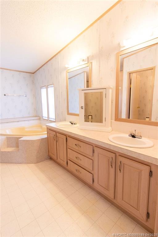 2500 Southwest Marquis Terrace Stuart, FL 34997 - Photo 16 of 20 a bathroom with a double vanity sink a bathtub and mirror