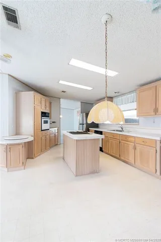 a kitchen with stainless steel appliances kitchen island granite countertop a stove a sink and a refrigerator