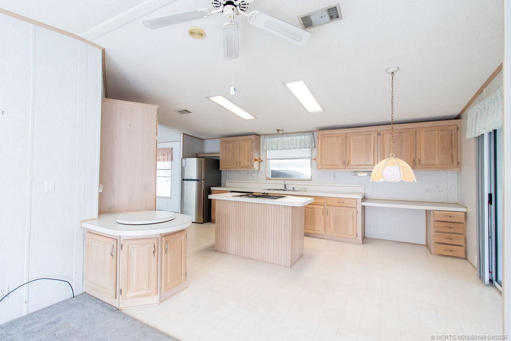 2500 Southwest Marquis Terrace Stuart, FL 34997 - Photo 6 of 20 a large kitchen with kitchen island a stove a sink dishwasher and white cabinets with wooden floor