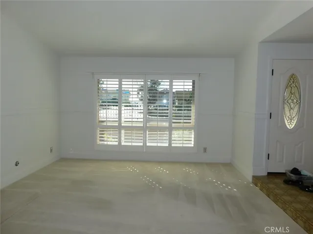 a view of empty room with wooden floor and window