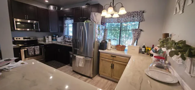 a kitchen with sink refrigerator and microwave