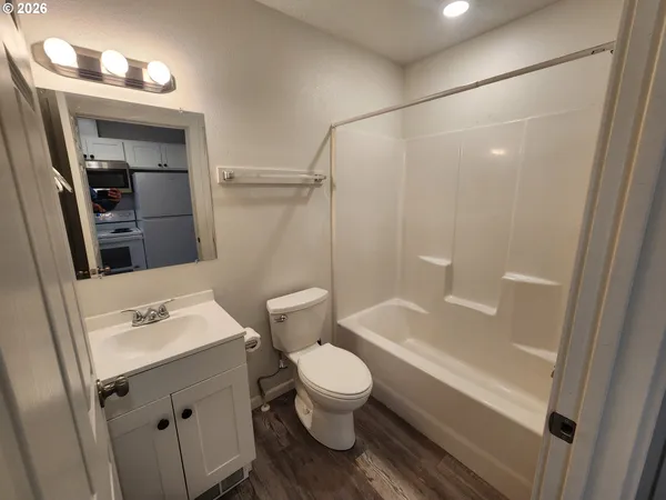 a bathroom with a sink a toilet a mirror and shower