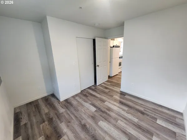 a view of empty room with wooden floor