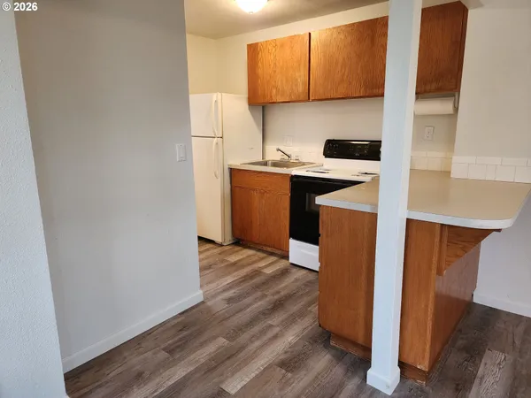 a kitchen with a sink a refrigerator and cabinets