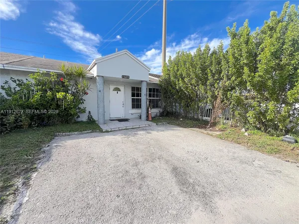 a view of a house with a yard and potted plants