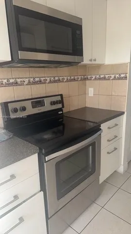 a stove top oven sitting inside of a kitchen