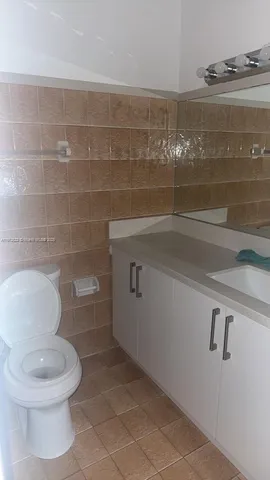 a bathroom with a toilet and a mirror