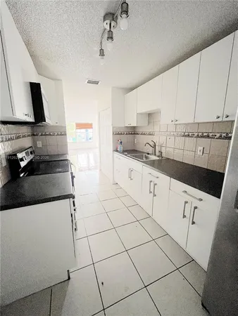 a kitchen with stainless steel appliances a sink stove and cabinets