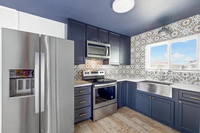 a kitchen with stainless steel appliances granite countertop a refrigerator stove and sink