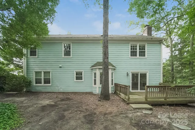 a view of a house with a yard and large tree